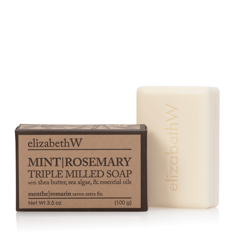 A bar of elizabeth W Purely Essential Mint Rosemary Triple-Milled Soap next to its packaging box, showcasing ingredients like shea butter, sea algae, and essential oils.