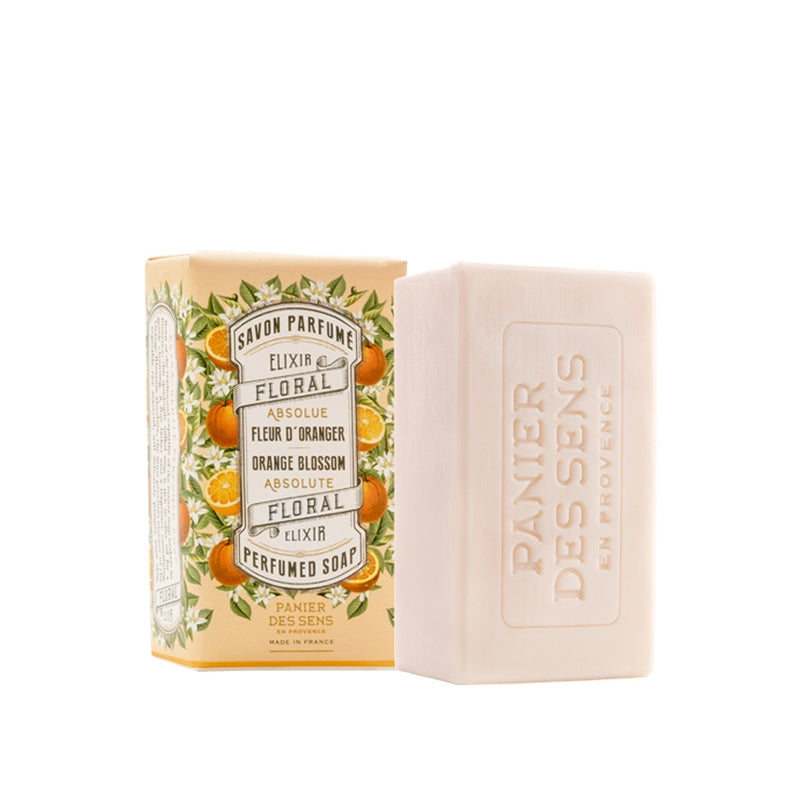 A bar of Panier Des Sens Orange Blossom Perfumed soap next to its packaging box. The box features ornate designs with orange blossom and floral motifs, and text that includes "savon parfumé" and "panier".