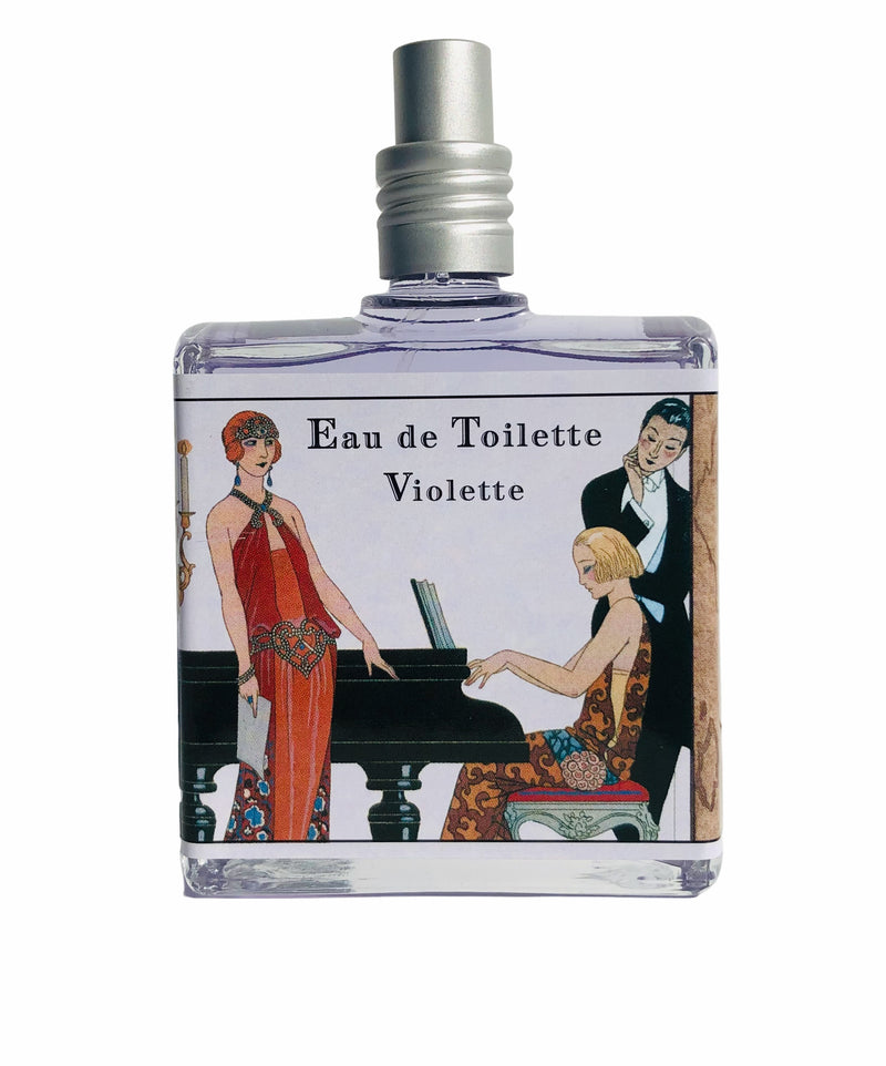 A glass perfume bottle labeled "Outremer - L'Aromarine Panorama Deco Eau de Toilette - Violette" features an Art Deco style illustration of a woman in a red dress and a man playing a piano.