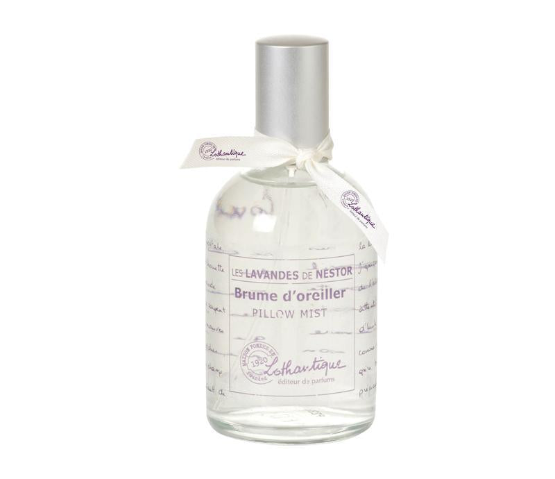 A clear glass bottle labeled "Lothantique Les Lavandes de l'oncle Nestor brume d'oreiller lavender pillow mist" with a white ribbon tied around the neck, on a white background.