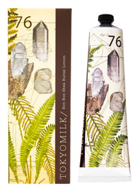 A tube and box packaging of Margot Elena TokyoMilk Radiant Gem No. 76 Bon Bon Shea Butter Lotion, both adorned with illustrations of clear crystals and lush green ferns, enhanced with elements of Lemon Balm in a dominant elegant color scheme.