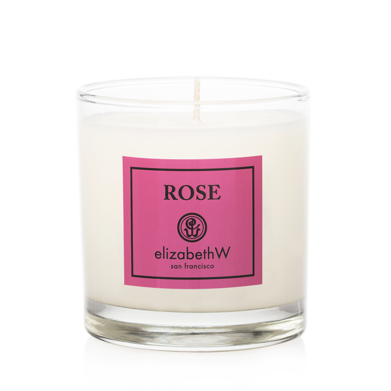 A forest berries-scented candle from elizabeth W in a clear glass container with a pink label, isolated on a white background.