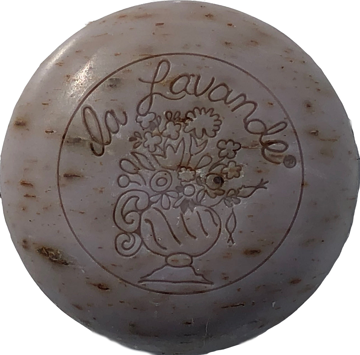Round, beige-colored La Lavande Round Lavender Flower Soap with the words "la lavande" engraved above a detailed floral bouquet of lavender buds within a vase, showcasing signs of light use and minor spotting.