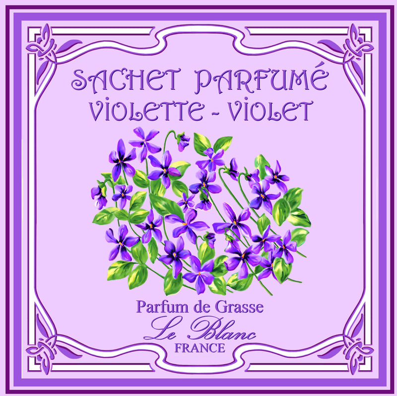 Illustration of a decorative Le Blanc Violet scented sachet label, featuring a circular arrangement of violet flowers with green leaves, bordered by elaborate purple and white designs, with text "sachet parfumé