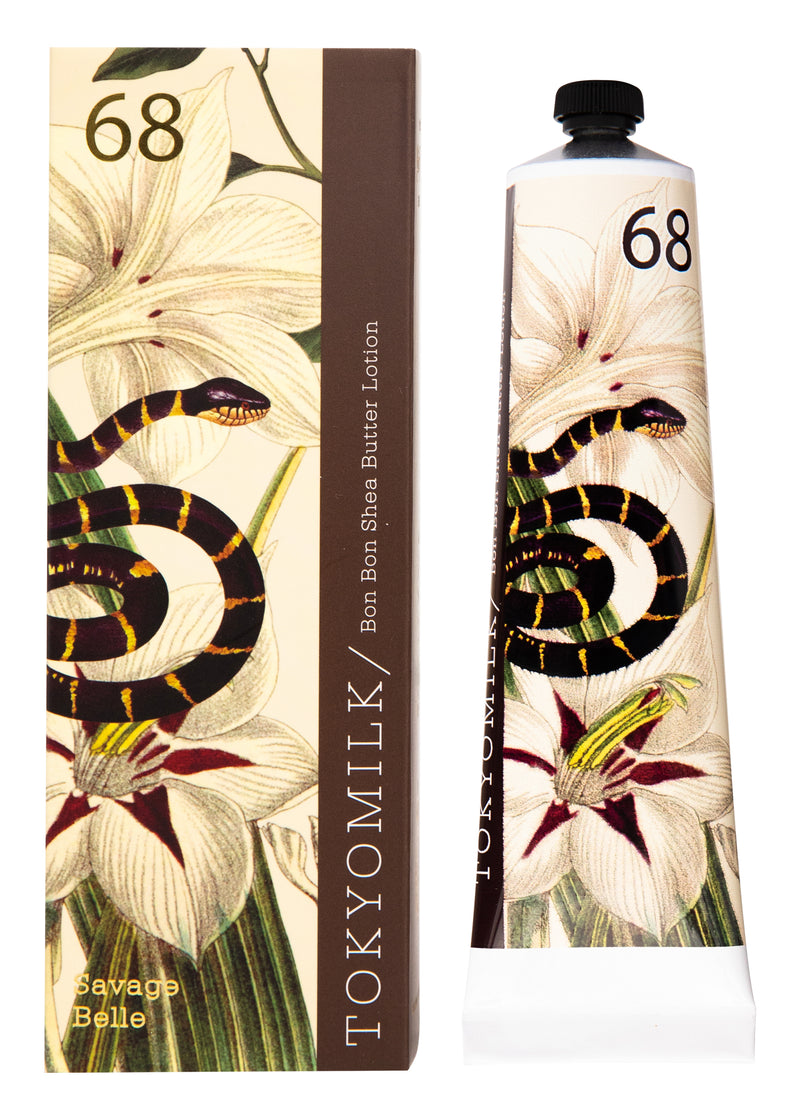 A tube and box of Margot Elena's TokyoMilk Savage Belle No. 68 Bon Bon Shea Butter Lotion, displaying a floral design with prominent white and yellow lilies on a beige background and enriched with...