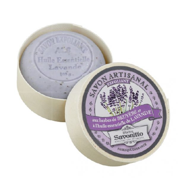 A round bar of Made in Provence Maitre Savonitto Lavender Exfoliating Wooden Box Soap, with lavender herbs and essential oils, including sweet almond oil, displayed in an open circular container with labels in French, emphasizing its natural ingredients.