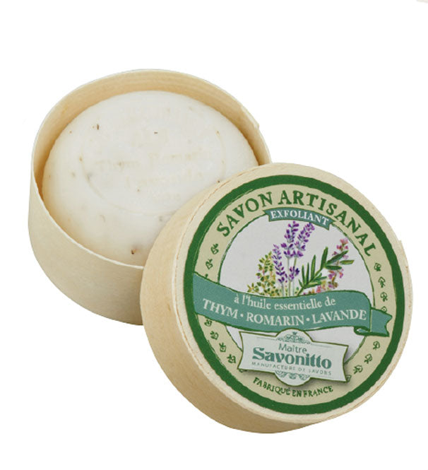 A round bar of Maitre Savonitto Thyme, Rosemary, Lavender exfoliating soap with sweet almond oil essential oils, displayed in a wooden container with its lid placed beside it. The label
Brand Name: EA2G