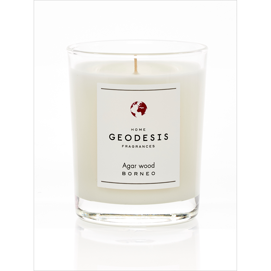 A white, Geodesis Agar Wood 180g scented candle in a clear glass labeled "geodesis agar wood borneo," with an intense scent, isolated on a white background.