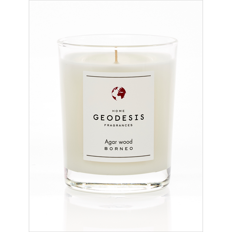 A white, Geodesis Agar Wood 180g scented candle in a clear glass labeled "geodesis agar wood borneo," with an intense scent, isolated on a white background.