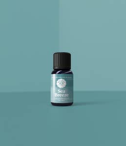 A small bottle labeled "Woolzies Sea Breeze Blend 10ml" on a plain teal background, exuding simplicity and minimalism. The label uses light blue and white colors.