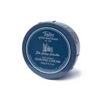 A navy blue circular container of Taylor of Old Bond Street Eton College Collection Shaving Cream Bowl 150g with citrus lemon notes, featuring silver text and trim, isolated on a white background.