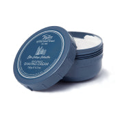 A small, round, dark blue Taylor of Old Bond Street container with its lid partially open, revealing a white shaving cream inside. The label on the lid features elegant text and design elements.