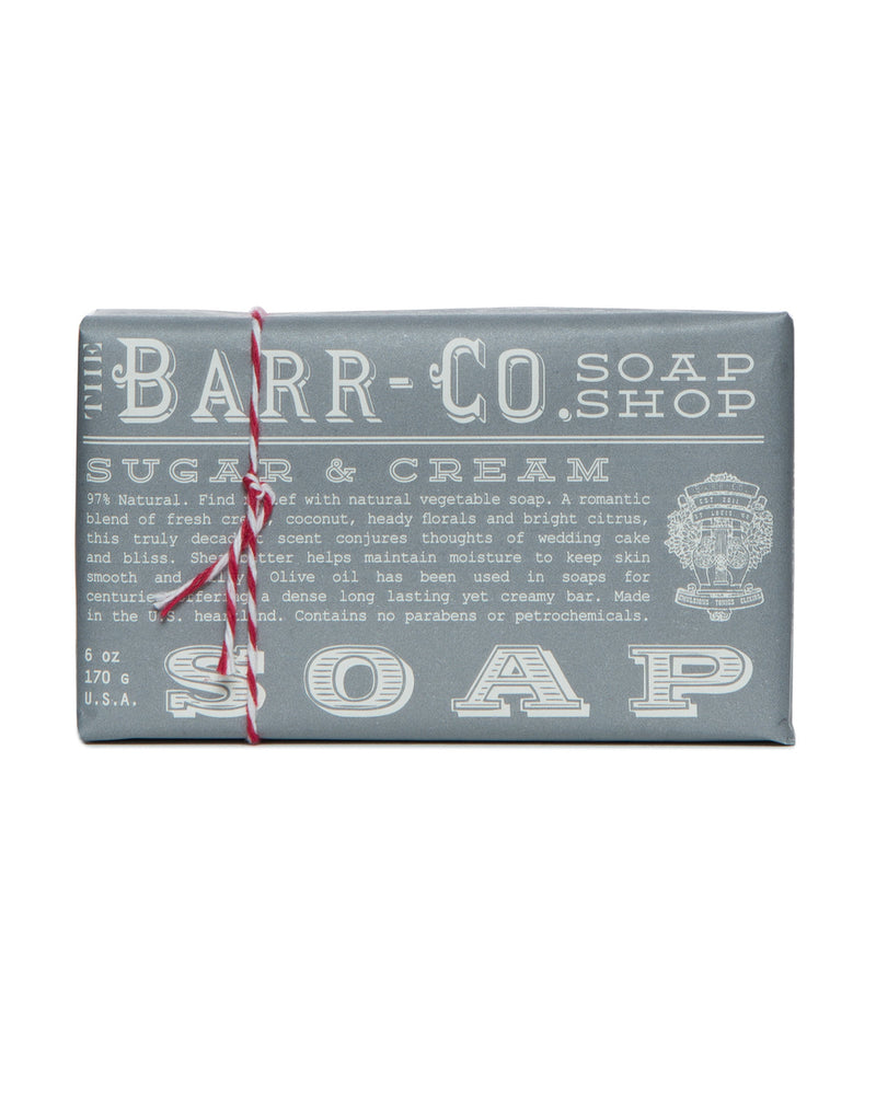 A Barr-Co. Sugar & Cream Triple Milled Bar Soap wrapped in silver paper with red and white twine, featuring printed text descriptions and logos.