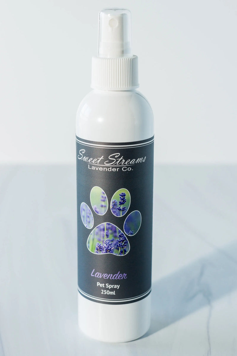 A white spray bottle labeled "Sweet Streams Lavender Co. - Lavender Pet Spray, 250ml" on a reflective surface. The label features lavender plant images.