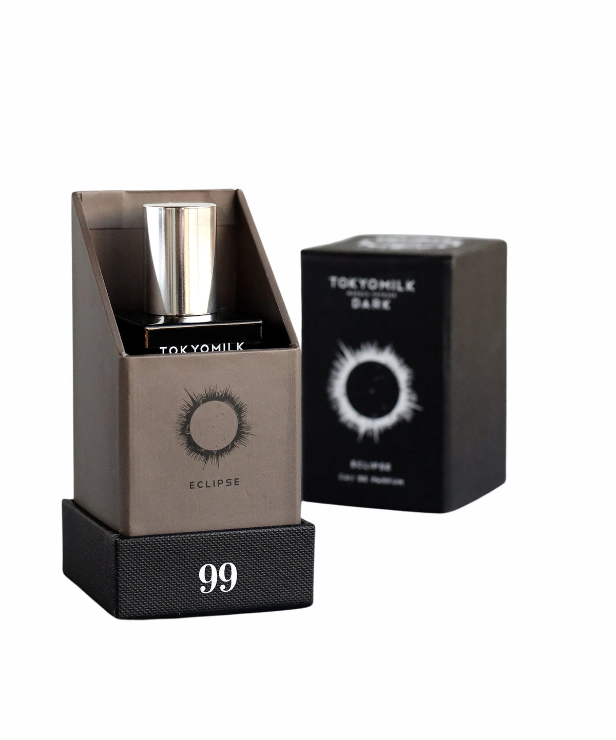 A bottle of "Margot Elena TokyoMilk Dark Eclipse No. 99 Eau de Parfum" displayed beside its packaging box, both set against a plain white background. The box features a graphic of an eye with a star.