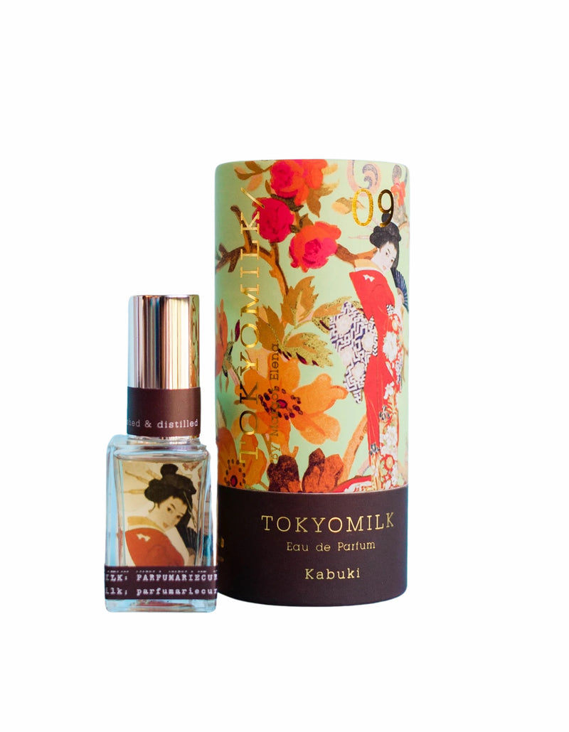 A TokyoMilk Kabuki No. 9 Eau de Parfum bottle by Margot Elena beside its cylindrical packaging featuring a sweet jasmine floral pattern and an illustration of a geisha.