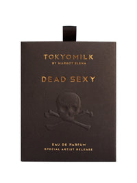 A black perfume box with a metallic imprint of a skull, crossbones, and the text "TokyoMilk Dead Sexy Elevated Embossed Eau De Parfum by Margot Elena, special artist release.