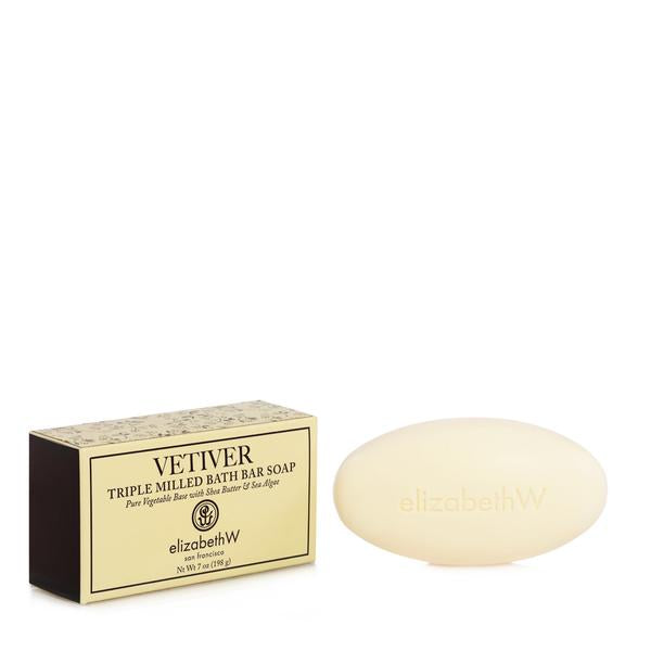 A bar of oval-shaped elizabeth W Signature Vetiver Soap - 7oz next to its packaging labeled "elizabeth w vetiver triple milled bath bar soap with shea butter." The packaging is in black and gold.