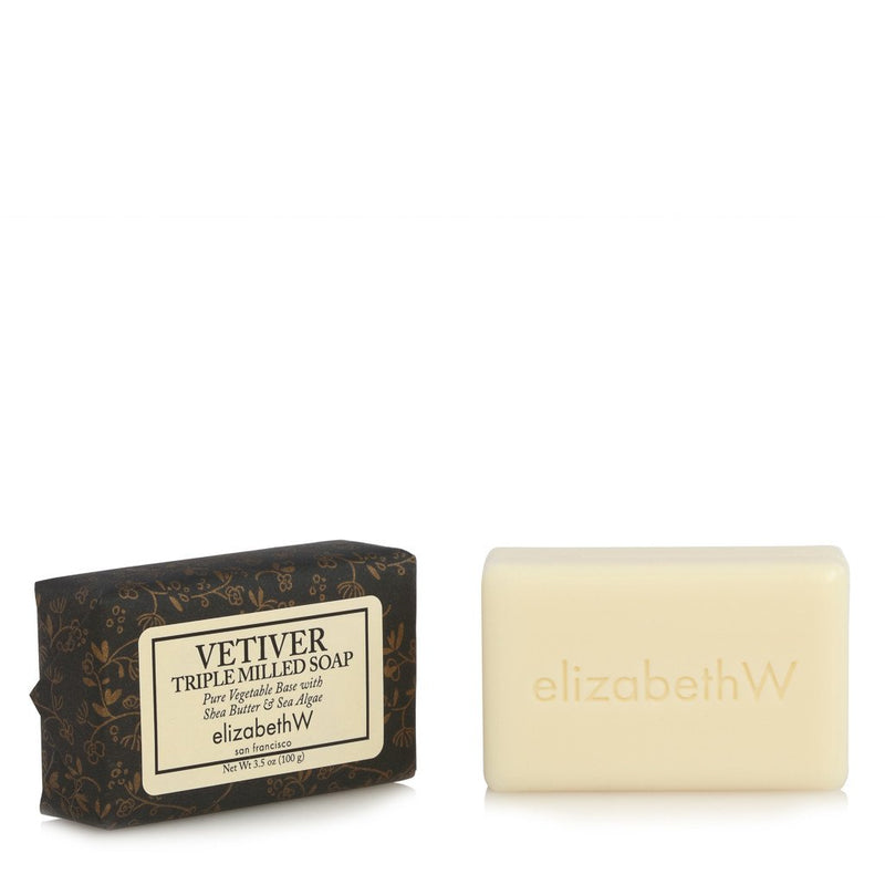 A bar of elizabethW Signature Vetiver Soap-3.5 oz next to its decorative packaging labeled "elizabeth W." The packaging features a floral design with brown and gold colors.