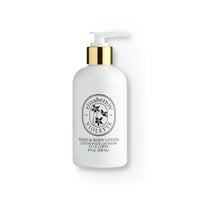A white dispenser bottle of elizabeth W Atelier Violette hand and body lotion, enriched with vitamin E and shea butter, features a gold pump, labeled in elegant black typography on a clean, isolated background.
